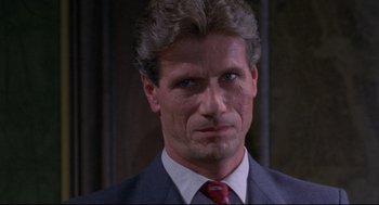 Movie still from “A Dry White Season” (1989), directed by Euzhan Palcy – A man in a suit and red tie looking at the camera; Close Up shot, Low angle