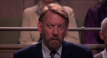 Movie still from “A Dry White Season” (1989), directed by Euzhan Palcy – A person wearing a suit and tie; Close Up shot, High angle