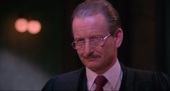 Movie still from “A Dry White Season” (1989), directed by Euzhan Palcy – An older man wearing a suit and tie; Close Up shot, Low angle