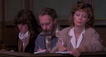 Movie still from “A Dry White Season” (1989), directed by Euzhan Palcy – A man and a woman writing on a notepad in front of another woman; Close Up shot, High angle