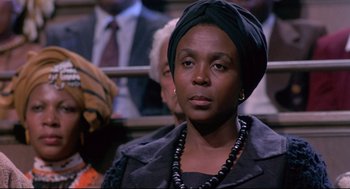 Movie still from “A Dry White Season” (1989), directed by Euzhan Palcy – An african american woman wearing a head scarf; Close Up shot, Over the shoulder angle