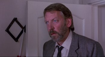 Movie still from “A Dry White Season” (1989), directed by Euzhan Palcy – A person wearing a suit and tie; Close Up shot, Low angle
