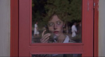 Movie still from “A Dry White Season” (1989), directed by Euzhan Palcy – A woman talking on a cell phone through a window; Close Up shot, Low angle