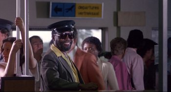 Movie still from “A Dry White Season” (1989), directed by Euzhan Palcy – A group of people standing in a room; Medium shot, Low angle