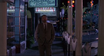 Movie still from “A Dry White Season” (1989), directed by Euzhan Palcy – A man in a business suit standing on the sidewalk; Wide shot, Low angle