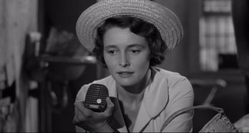 Movie still from “A Face in the Crowd” (1957), directed by Elia Kazan – A black and white photo of a woman holding a microphone; Close Up shot, High angle