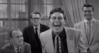 Movie still from “A Face in the Crowd” (1957), directed by Elia Kazan – A man in a suit and a tie laughing; Medium shot, Over the shoulder angle