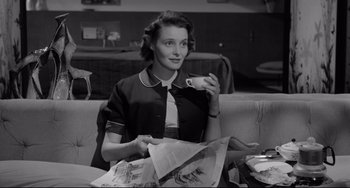 Movie still from “A Face in the Crowd” (1957), directed by Elia Kazan – A black and white photo of a woman sitting at a table; Medium shot, High angle