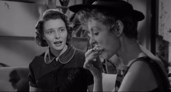 Movie still from “A Face in the Crowd” (1957), directed by Elia Kazan – Two women are looking at each other while one is smoking a cigarette; Medium shot, Over the shoulder angle