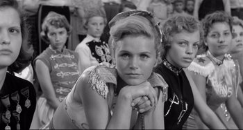 Movie still from “A Face in the Crowd” (1957), directed by Elia Kazan – A black and white photo of a woman in a crowd; Medium shot, Low angle