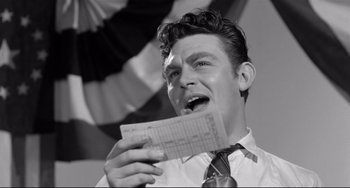 Movie still from “A Face in the Crowd” (1957), directed by Elia Kazan – A black and white photo of a man holding a piece of paper; Close Up shot, Low angle