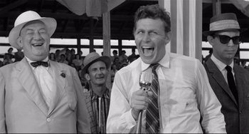 Movie still from “A Face in the Crowd” (1957), directed by Elia Kazan – An old photo of a man holding a microphone; Medium shot, Over the shoulder angle
