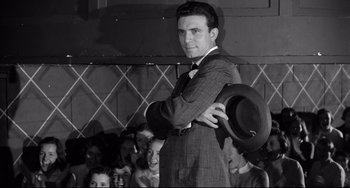 Movie still from “A Face in the Crowd” (1957), directed by Elia Kazan – A black and white photo of a man holding a hat; Medium shot, Low angle