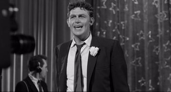 Movie still from “A Face in the Crowd” (1957), directed by Elia Kazan – Black and white photograph of a man wearing a suit and tie; Medium shot, Low angle