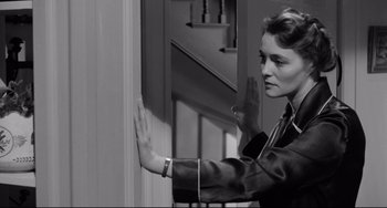 Movie still from “A Face in the Crowd” (1957), directed by Elia Kazan – A black - and - white photo of a woman holding her hands up; Medium shot, Over the shoulder angle