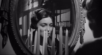 Movie still from “A Face in the Crowd” (1957), directed by Elia Kazan – A black and white photo of a woman looking in a mirror; Close Up shot, Over the shoulder angle