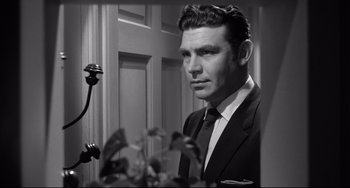 Movie still from “A Face in the Crowd” (1957), directed by Elia Kazan – Black and white photograph of a man wearing a suit and tie; Close Up shot, Low angle