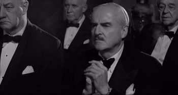 Movie still from “A Face in the Crowd” (1957), directed by Elia Kazan – A black and white photo of a man in a tuxedo; Medium shot, Low angle