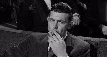 Movie still from “A Face in the Crowd” (1957), directed by Elia Kazan – A black and white photo of a man smoking a cigarette; Close Up shot, High angle