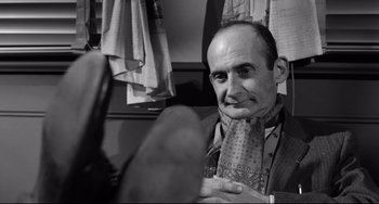 Movie still from “A Face in the Crowd” (1957), directed by Elia Kazan – An older man wearing a suit and a tie; Close Up shot, Low angle