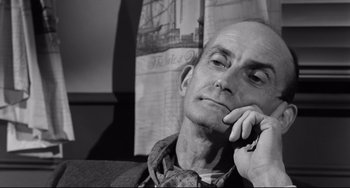 Movie still from “A Face in the Crowd” (1957), directed by Elia Kazan – An older man sitting in front of an old newspaper; Close Up shot, Low angle