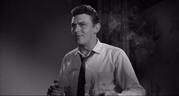 Movie still from “A Face in the Crowd” (1957), directed by Elia Kazan – A black and white photo of a man smoking a cigarette; Close Up shot, High angle