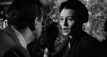 Movie still from “A Face in the Crowd” (1957), directed by Elia Kazan – A woman holding a cigarette in front of another woman; Close Up shot, Over the shoulder angle