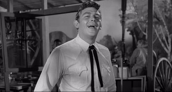 Movie still from “A Face in the Crowd” (1957), directed by Elia Kazan – A black and white photo of a man laughing; Medium shot, Low angle