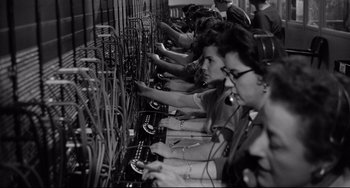 Movie still from “A Face in the Crowd” (1957), directed by Elia Kazan – A group of people working in a telephone exchange; Medium shot, Overhead angle