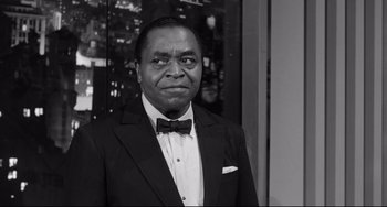 Movie still from “A Face in the Crowd” (1957), directed by Elia Kazan – A man in a suit and a bow tie; Medium shot, Over the shoulder angle