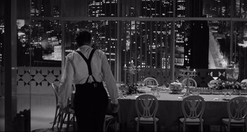 Movie still from “A Face in the Crowd” (1957), directed by Elia Kazan – A man standing in front of a dining room table; Wide shot, Over the shoulder angle