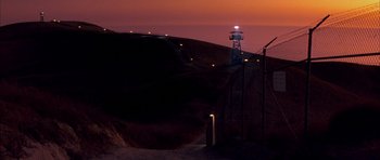 Movie still from “A Few Good Men” (1992), directed by Rob Reiner – A view of a light tower at night from the side of a hill; Extreme Wide shot, Low angle