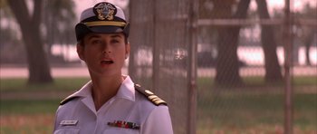 Movie still from “A Few Good Men” (1992), directed by Rob Reiner – A woman in a uniform is standing in front of a chain link fence; Close Up shot, Low angle