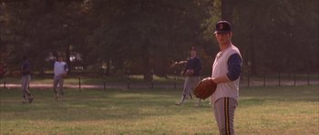 Movie still from “A Few Good Men” (1992), directed by Rob Reiner – A man holding a catchers mitt on top of a grass covered field; Wide shot, Over the shoulder angle