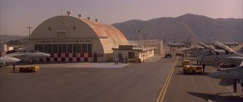 Movie still from “A Few Good Men” (1992), directed by Rob Reiner – People are standing in front of an airplane hangar; Extreme Wide shot, High angle