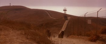 Movie still from “A Few Good Men” (1992), directed by Rob Reiner – A group of people riding down a dirt road next to a hill; Extreme Wide shot, High angle