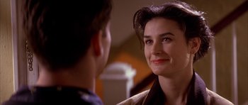 Movie still from “A Few Good Men” (1992), directed by Rob Reiner – A woman smiles at the camera while a man looks on; Close Up shot, Over the shoulder angle