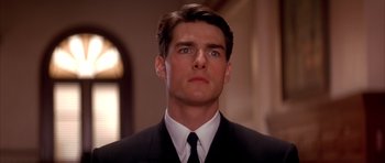 Movie still from “A Few Good Men” (1992), directed by Rob Reiner – A man in a black suit and white tie looking to his left; Close Up shot, Low angle