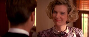 A woman in a red and black dress looking at a man in a suit