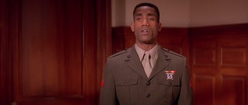 Movie still from “A Few Good Men” (1992), directed by Rob Reiner – A man in a military uniform standing in front of a wooden wall; Close Up shot, Low angle