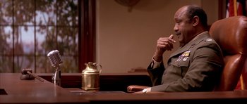 Movie still from “A Few Good Men” (1992), directed by Rob Reiner – A man sitting at a table in front of a tea pot; Medium shot, Low angle