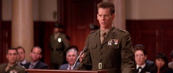 Movie still from “A Few Good Men” (1992), directed by Rob Reiner – A man in a military uniform standing at a podium; Medium shot, Low angle