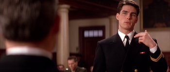 Movie still from “A Few Good Men” (1992), directed by Rob Reiner – A man in a suit and tie standing in front of other people; Close Up shot, Over the shoulder angle