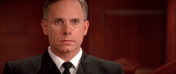 Movie still from “A Few Good Men” (1992), directed by Rob Reiner – A person wearing glasses and a suit; Close Up shot, Low angle