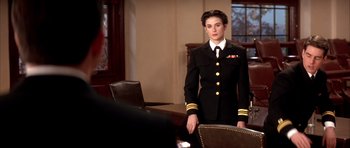 Movie still from “A Few Good Men” (1992), directed by Rob Reiner – A woman in a uniform standing in front of a table; Medium shot, Over the shoulder angle