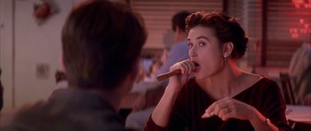 Movie still from “A Few Good Men” (1992), directed by Rob Reiner – A woman holding a cigar in front of another woman; Close Up shot, Over the shoulder angle