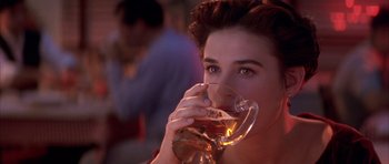 Movie still from “A Few Good Men” (1992), directed by Rob Reiner – A woman drinking a glass of beer at a party; Close Up shot, Over the shoulder angle