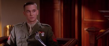 Movie still from “A Few Good Men” (1992), directed by Rob Reiner – A man in a military uniform sitting at a podium; Close Up shot, Low angle
