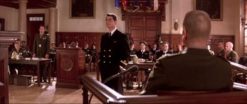 Movie still from “A Few Good Men” (1992), directed by Rob Reiner – A man standing in front of a group of people in a courtroom; Wide shot, Over the shoulder angle