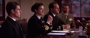 Movie still from “A Few Good Men” (1992), directed by Rob Reiner – A woman in a military uniform sitting at a table; Medium shot, Low angle